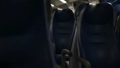 Gazing fearfully between the empty seats of a train carriage Stock Footage 154822106