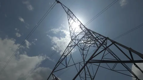 Gazing skyward, a lattice tower vaults into the sun, a geometric giant grid fuel Video stock 340514670