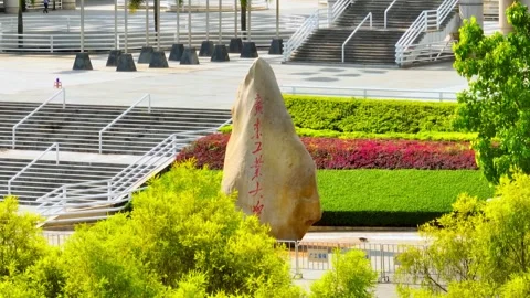 GDUT stone monument framed by leafy trees in Guangzhou China Stock Footage 345954568
