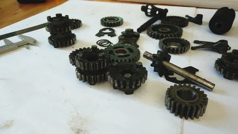 Gear and part of machine on engineer desk. Panning right shot. Stock Footage 119530535