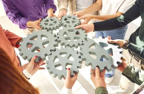 Gear elements team hands holding, teambuilding mechanically engineering toy 库存照片