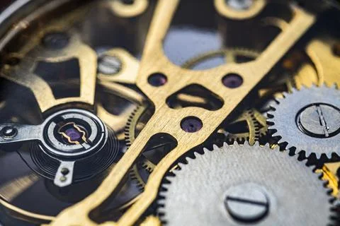 Gears and cogs inside clock. Close-up view on retro watches. Stock Photos