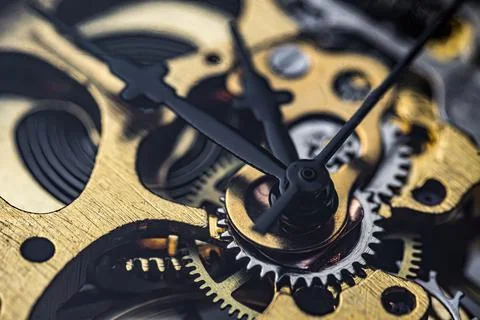 Gears and cogs inside clock. Close-up view on retro watches. Stock Photos