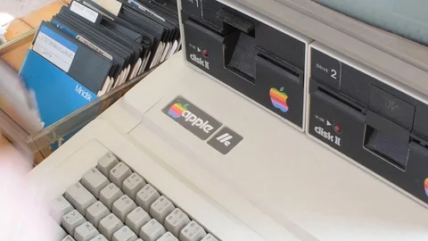 Ged Apple computer and hand insert floppy inside then  typing on keyboard Stock Footage 91186772