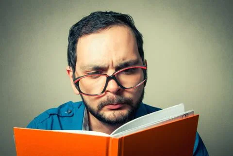 Geek with the beard reading Stock-Fotos