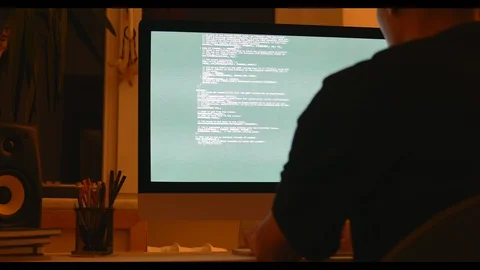 Geek man programmer working at home in loft room writing programming code for Stock Footage 115491883