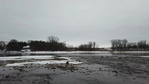 Geese flying ion the background of a flowing river Stock Footage 144052608