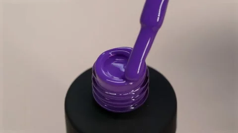 Gel polish violet thick texture. Varnish flows from a brush into a black tube Stock Footage 168871913