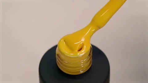 Gel polish yellow thick texture. Varnish flows from a brush into a black tube Stock Footage 168872075