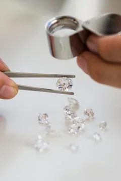 Gemologist inspecting diamonds using loupe Stock Photos