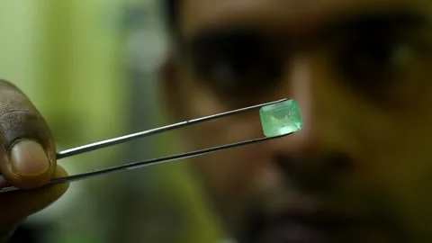 Gemologist inspecting an emerald Video stock 144557055