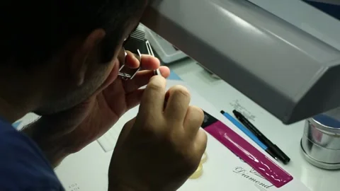 Gemologist working in workshop. Gemololist looking diamond gem Stock Footage 134384768