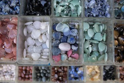 Gemstone pendants assortment in plastic boxes Stock Photos