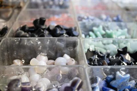 Gemstone pendants assortment in plastic boxes Stock Photos