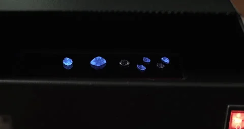 Gemstones in UV light box. UV lamp for testing the fluorescence of gemstones Stock Footage 256926113