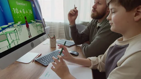 Gen Alpha Boy Doing Math Exercise in Computer Game with Father at Home Stock Footage 332779161