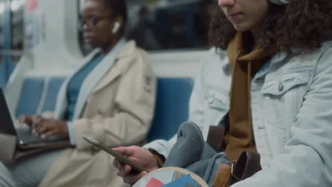 Gen Z Guy with Mobile and Headphones Riding Metro Train with Skateboard Stock Footage 265965184
