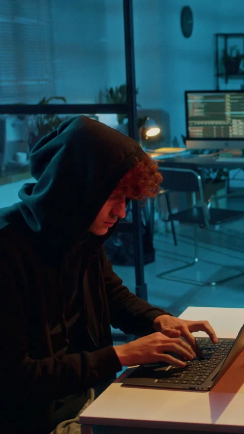Gen Z Hacker Installing Malicious Drivers on Companys Laptop in Dim Light Stock Footage 299237269