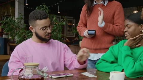 Gen Z Man Looking at Restaurant Bill and Giving Money to Waitress in Cafe Stock Footage 333259292