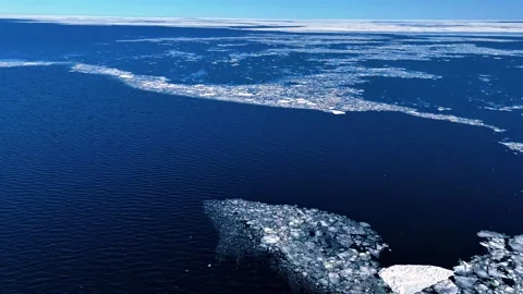 General cargo ship sailing between floating sea ice fields Stock Footage 335356966