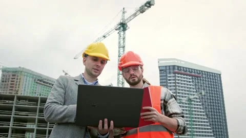 General contractor and subcontractor using laptop during site inspection Stock Footage 274394438