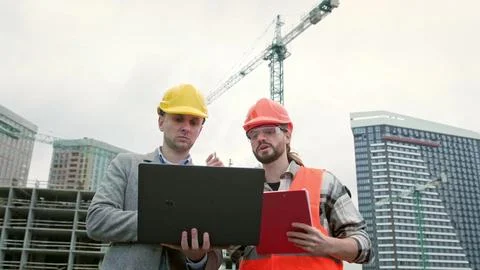 General contractor and subcontractor using laptop during site inspection Fotos de archivo