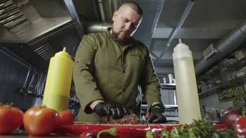 General plan of the chef in the background of the kitchen marinating the meat. Stock Footage 234179530
