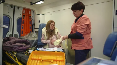General plan in the frame. Paramedic putting on rubber sterile gloves to provide 스톡 동영상 254182510