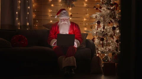 General plan Front view A real Santa Claus is working with a laptop at night Stock Footage 166158383