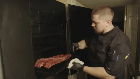 The general plan is how the chef puts the raw ribs in the smoker and closes it. Stock Footage 236538368