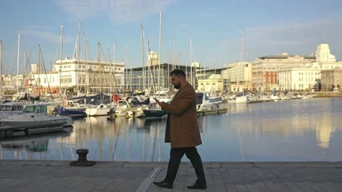 General plan, a man in a coat goes and says something, holds a phone in his Stock Footage 219766784