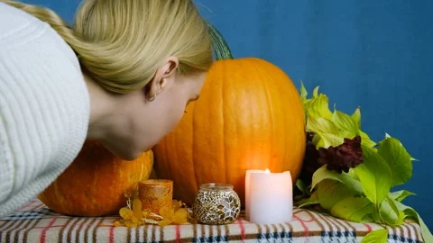 General plan of pumpkins and candles. The girl blows out a candle. Stock Footage 210177547