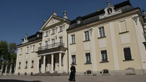 The general plan shot of a historical building and a man walks in front of it Stock-Footage 103356442