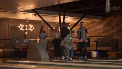 General plan A young man in a shirt bowling player throws a ball with the Stock Footage 166494089