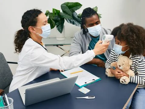 General practitioner checking body temperature of a child patient using inf.. Foto stock