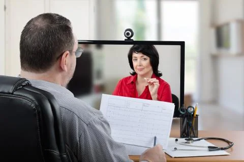 General practitioner checking heart-rate graph with remote patient Foto stock