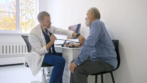 A general practitioner measures the blood pressure of an elderly patient Stock Footage 255185141