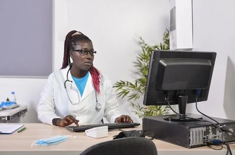 General practitioner working on computer in medical office Stock Photos