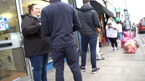 General Public queuing for Covid-19 Vaccine  outside a pharmacy in London Stock Footage 167009758