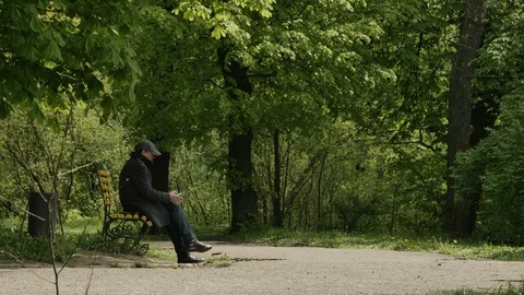 General shot of a man sitting on the bench and using hos mobile phone 库存影片 103252241