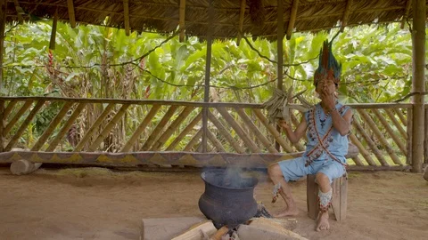 General shot of an old indigenous men smokes magical herbs to perform a Stock Footage 113178565