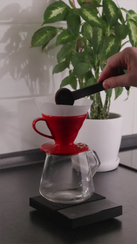 General shot of pouring ground coffee into red V60 dripper Stock Footage 332720146