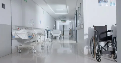 General view of empty hospital corridor with wheelchair and patient beds in slow Stock Footage 338060083