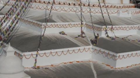 General view of man hanging prayer flags on Boudha stupa. Video stock 241736062