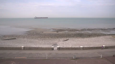 General view of sand beach and cargo ship in the background Stock-Footage 68704534
