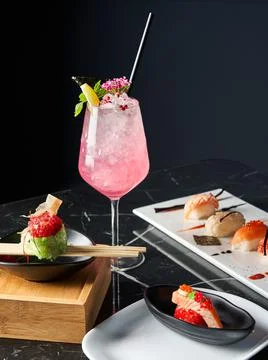 General view of table with a refreshing drink, white plate of sushi pieces. Food Stock Photos