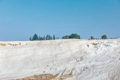 General view of top of white mountain Pamukkale in Turkey and blue sky. Stock Photos