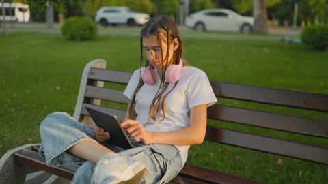Generation Alpha, Modern young person browsing internet on tablet outdoors near Stock Footage 340924790
