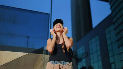 Generation Z, Adolescent putting pink wireless headphones on her head in the Stock Footage 340479208