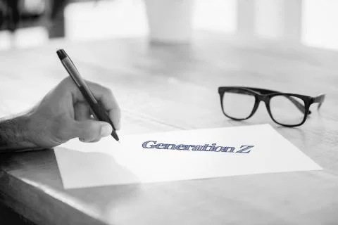 Generation z against side view of hand writing on white page on working desk Stock Illustration